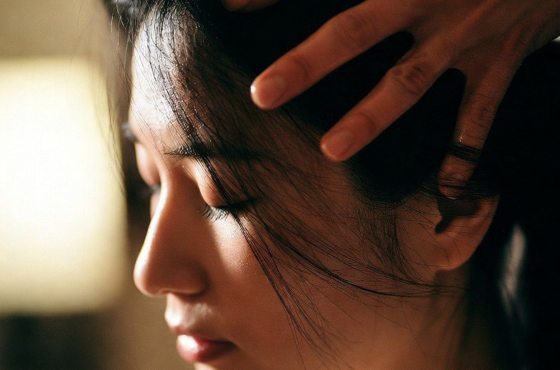 頭部への優しく触れる施術の様子